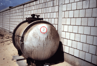 Figure 7. Photographs of the storage tank at the Kuwaiti Girls' School taken by the safety officer in August 1991. Encircled areas show the movement of the fumes out of one of the bullet holes. (Photographs used by permission.)