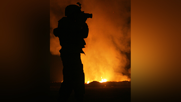 Image of U.S. Army Sgt. Robert B. Brown with Regimental Combat Team 6, Combat Camera Unit, takes a photograph of firefighters at the Fallujah, Iraq.