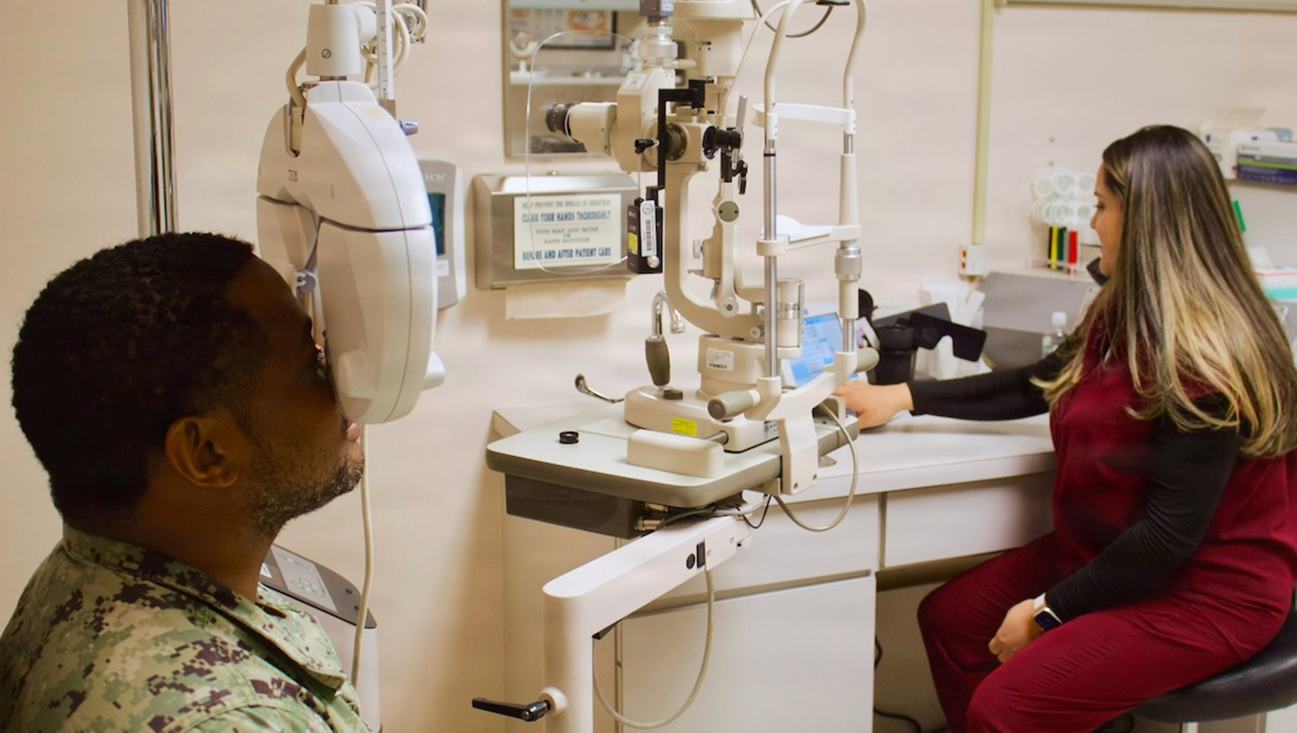 Catherine Ortiz (right), a Doctor of Optometry student form Western University of Health Sciences, conducts an eye examination with Hospital Corpsman 2nd Class Emilio Matthew