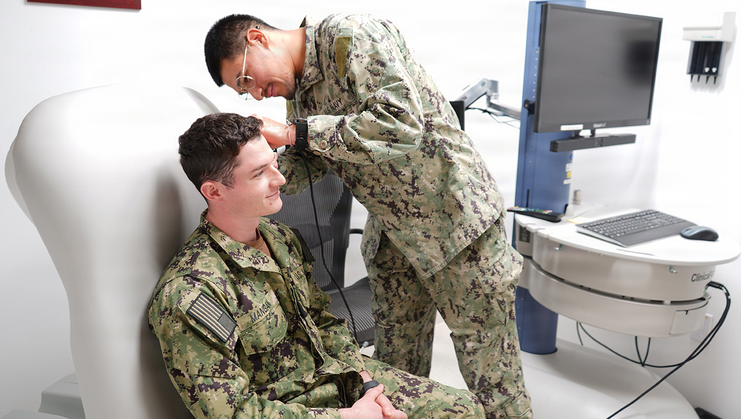 Hospital Corpsman 3rd Class Martin E. Romero Alvarez, a native of Dalton, Georgia, assigned to Navy Medicine Readiness and Training Command Rota, demonstrates a physical ear examination on a Sailor using a telehealth medical cart