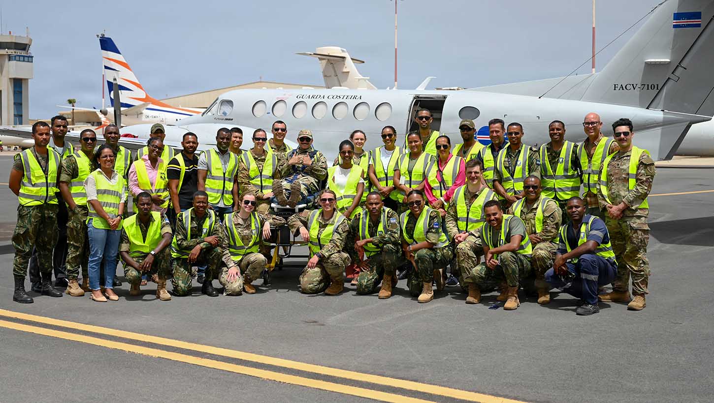New Hampshire National Guard members, Cabo Verde Armed Forces Medical Unit members and medical professionals from the Ministry of Health pose for a group photo in front of a C-12 Huron multipurpose aircraft
