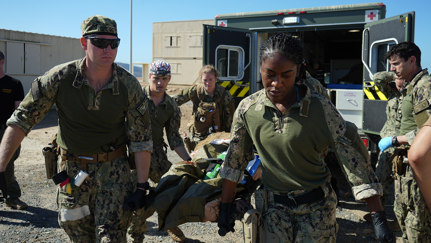 Hospital Corpsman 2nd Class Nya Jobs (right), respiratory therapist, Lt. j.g. Mark Gregg (left), trauma nurse, Capt. David Samaha (middle), general surgeon, and Lt. j.g. Melissa Sullivant (back), trauma nurse, all assigned to Navy Medicine Readiness and Training Command (NMRTC) Jacksonville, transport a casualty from an ambulance into their mission support site during an Expeditionary Resuscitative Surgical System (ERSS) course