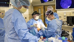 Army Spc. Katie Alexander organizes surgical tools while Army Lt. Col. Jeffrey Teixeira and Army Maj. Jonathan Buttram surgically repair a fractured eye socket 