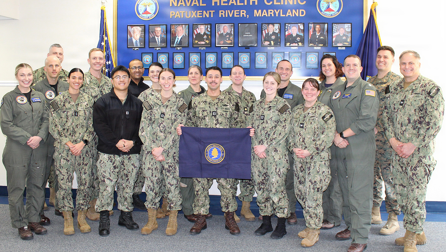 Capt. Kristin Hodapp (front row, center), Deputy Chief of the Navy Medical Service Corps (MSC), and Capt. Bryan Pyle (front row, far right), MSC Policy and Practice, pose for a group photo with MSC officers stationed across Naval Air Station Patuxent River following a "State of the Corps" address. The officers represent all three pillars of the MSC—Healthcare Administration, Clinical Care, and Research and Applied Sciences. Pictured front row, left to right: Lt. Brittany Neilson, Lt. j.g. Alisha Deschenes, Lt. Brandon Le, Lt. Natalie Grose, Lt. Matthew Sierra, Lt. Kayleigh Gutierrez, Hodapp, Cmdr. Adam Preston, and Pyle. Back row, left to right: Lt. Cmdr. Jarrett Moore, Lt. Cmdr. Matthew Christensen, Lt. Cole Engstrom, Lt. Arbi Aghali, Lt. Madeline Smith, Lt. Cmdr. Juliette Ruff, Lt. Cmdr. Danielle Whitacre, Lt. Cmdr. Kyle Shepard, Lt. Cmdr. Hadley Sulpizio, and Lt. Chase Cribbs
