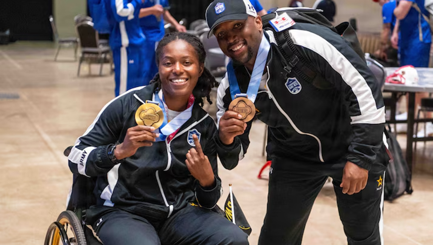 Army 1st Lt. Jani Merritt, left, and Army Capt. Tony Smith pose with their medals after wining the powerlifting competition at the 2026 Warrior Games