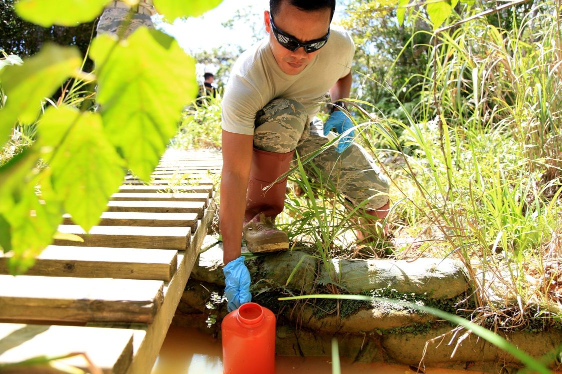 Tech. Sgt. Donny Aspiras gathers a sample of water from the “pit and pond” obstacle Sept. 15.