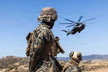 Two service members turned toward a helicopter