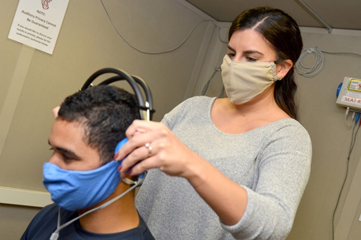 Image of An audiology technician at Naval Branch Health Clinic Jacksonville’s occupational health clinic, conducts a hearing exam with Airman Diosney Moraga.