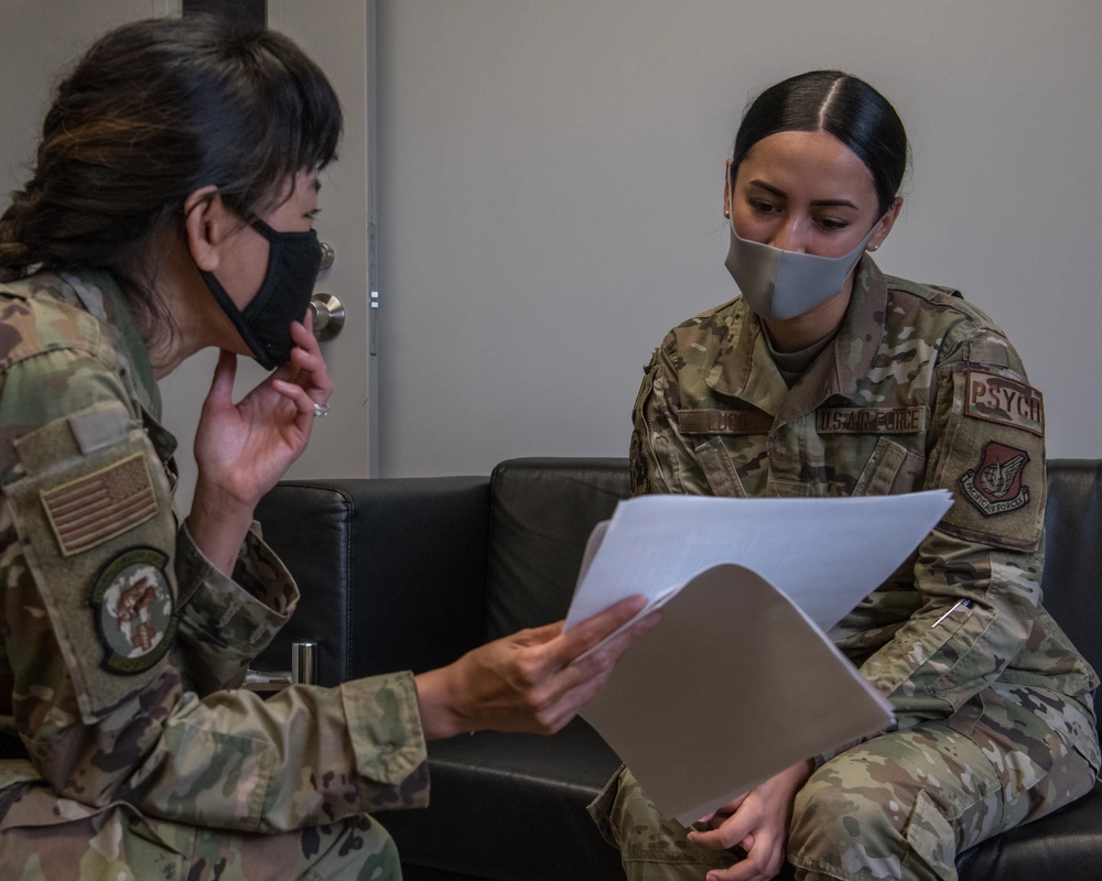 U.S. Air Force Airman 1st Class Miranda Lugo, right, 18th Operational Medical Readiness Squadron mental health technician and Guardian Wingman trainer, and Maj. Joanna Ho, left, 18th OMRS director of psychological health, discuss the suicide prevention training program, Guardian Wingman, at Kadena Air Base, Japan, Aug. 20, 2021. Guardian Wingman aims to promote wingman culture and early help-seeking behavior. (U.S. Air Force photo by Airman 1st Class Anna Nolte)
