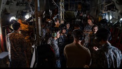 U.S. Air Force 18th Aeromedical Evacuation Squadron members and Japan Air Self-Defense Force AES members discuss bilateral training in a KC-130J Hercules assigned to Marine Aerial Refueler Transport Squadron 152 during bilateral training