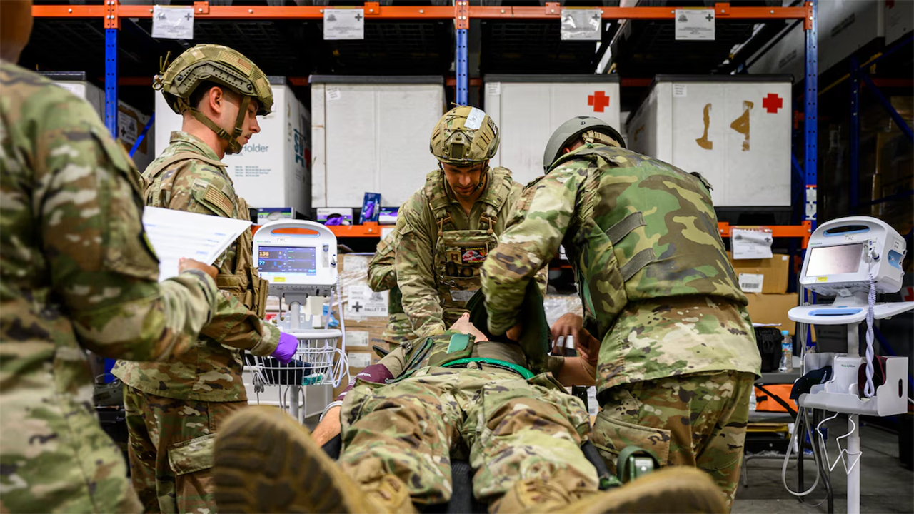 U.S. Air Force medical personnel assigned to the 18th Medical Group assess the injuries of a simulated patient following a notional attack during an En-Route Patient Staging System exercise