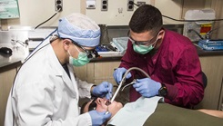 U.S. Navy Hospitalman Justin Sobleskie (right), and U.S. Navy Lt. Matthew Roberts, USS Carter Hall dental department head, do dental work on aboard the USS Carter Hall (LSD 50) while at sea.