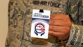 Image of soldier holding up a badge that says "Trusted Care."