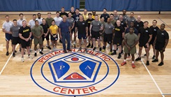Military personnel posing for a picture in a gym