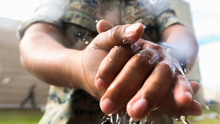 Marines with Marine Wing Headquarters Squadron, 3rd Marine Aircraft Wing take precautionary measures by cleaning and disinfecting their hands during field day on Marine Corps Air Station Miramar, Calif., March 20, 2020, to mitigate the spread of COVID-19 while continuing to perform mission-essential tasks. (Photo: Marine Corps Lance Cpl. Jaime Reyes)