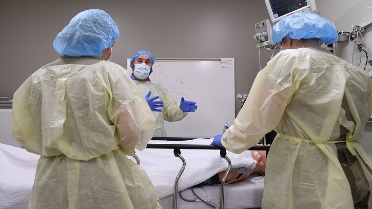 Three surgeons discussing a patient on an operating table