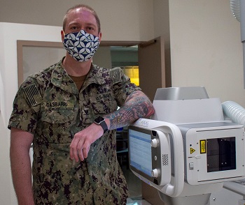 Hospital Corpsman in mask poses with new medical equipment