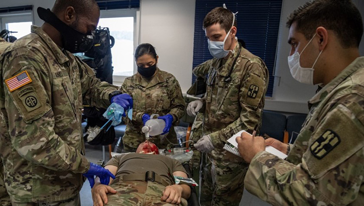 Image of Soldiers practicing burn care on dummies. Click to open a larger version of the image.