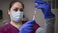 Medical technician getting a syringe ready to give a vaccine