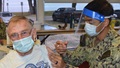 Military medical personnel giving a vaccine shot to a soldier