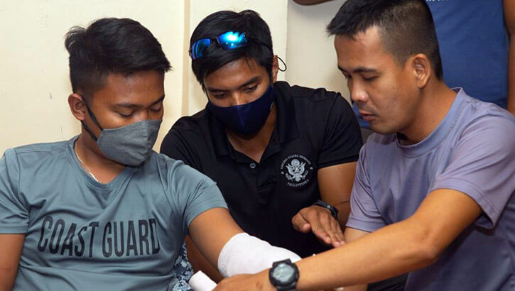 Military medical personnel preparing bandage