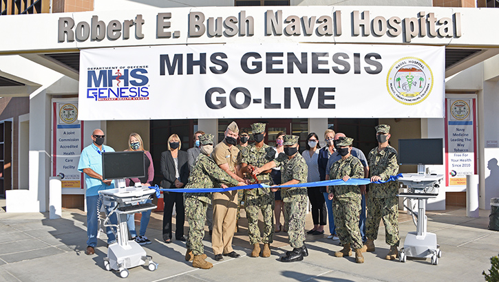 Image of Military personnel standing in front of hospital with sign "MHS GENESIS GO-LIVE". Click to open a larger version of the image.
