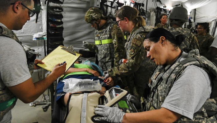 Military medical personnel perform mock emergency care