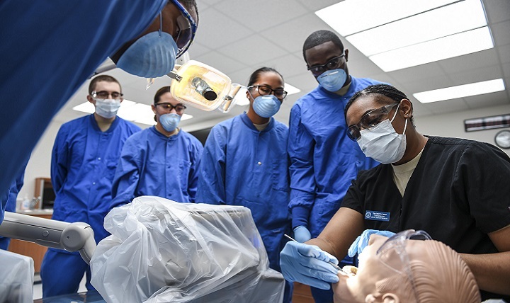 Air Force Tech. Sgt. Christy Nixon (right), NCO in charge of the Air Force Dental Assistant training program at the Medical Education and Training Campus on Joint Base San Antonio-Fort Sam Houston, Texas, instructs students on how to properly give an oral examination. 