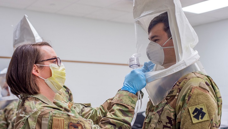Army technician fits soldier with face mask