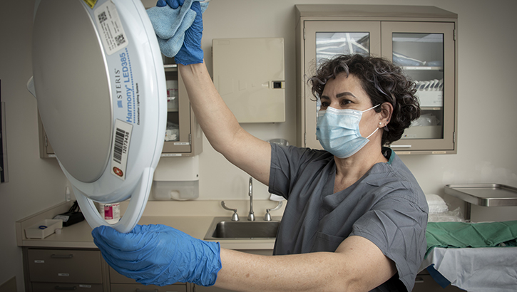 Rosa Jimenez, housekeeper, cleans a patient exam room at Brooke Army Medical Center, Fort Sam Houston, Texas, March 25, 2022. BAMC received the 2022 Practice Greenhealth Partner for Change Award and the Greening the OR Recognition Award. (DOD photo: Jason W. Edwards)