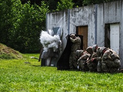 Military personnel blast down a door