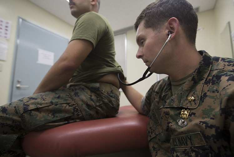 Image of A U.S. naval officer listens through his stethoscope to hear his patient’s lungs at Camp Schwab in Okinawa, Japan in 2018. (Photo courtesy of U.S. Marine Corps) photo by Lance Cpl. Cameron Parks). Click to open a larger version of the image.