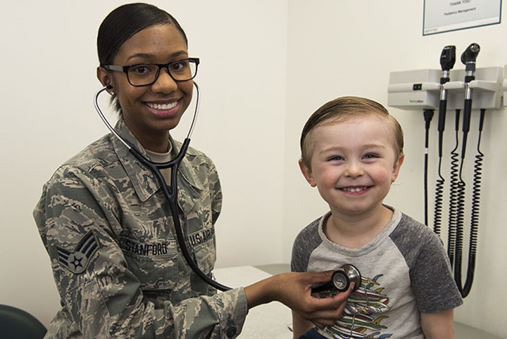 Image of A senior airman of 366th Medical Support Squadron pediatric clinic checks vitals of the child of its service member at Mountain Home Air Force Base in Idaho. (Photo courtesy of U.S. Air Force).
