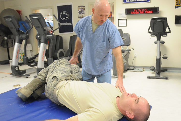 U.S. Air Force Capt. Sean Wilson, a native of Winston-Salem, N.C., and a physical therapist with the 59th Orthopedic and Rehabilitation Squadron, teaches a patient some home exercises that he can perform on his own at the Craig Joint-Theater Hospital, Jan. 23, 2012. (U.S. Air Force photo by Spc.Cody Barber, Bagram Air Field, Afghanistan/Released)