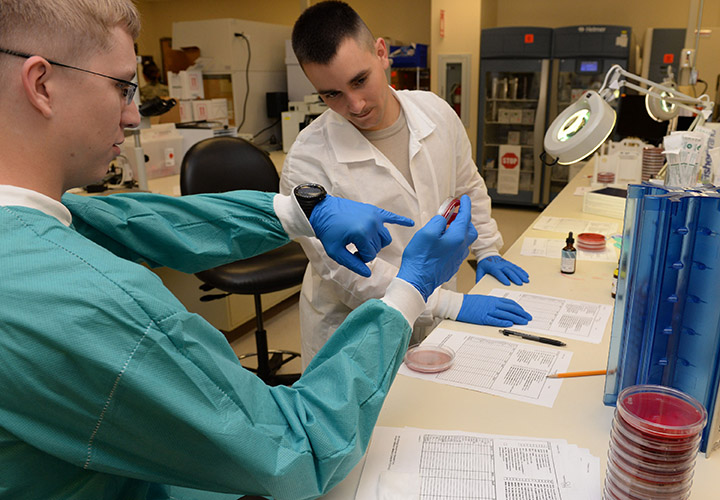 The (left to right) Senior Airman Austin Shrewsbury, 88th Diagnostics and Therapeutic Squadron medical laboratory technician, works with student, Airman 1st Class Taylor Altman, 88th Diagnostics and Therapeutic Squadron medical laboratory technician, to identify bacteria of patient’s cultures inside the microbiology laboratory at Wright-Patterson Air Force Base medical center June 30, 2017. 