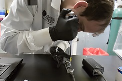 Dr. Peter Larson loads an Oxford Nanopore MinION sequencer in support of COVID-19 sequencing assay development at the U.S. Army Medical Research Institute of Infectious Diseases, Fort Detrick, Maryland. (Photo by John Braun Jr., USAMRIID.)