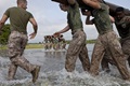 Image of Marines carrying a wooden log for physical fitness. Click to open a larger version of the image.