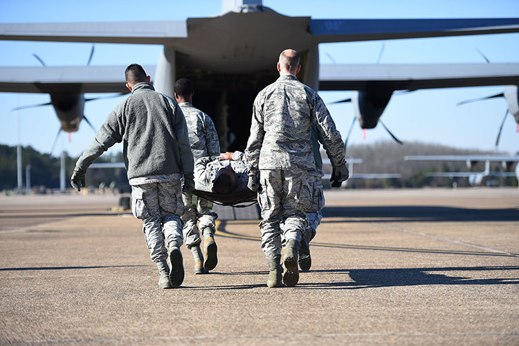 Airmen from the 19th Medical Group litter-carry a simulated patient onto a C-130J during an aeromedical evacuation training mission at Little Rock Air Force Base in 2019. (U.S. Air Force photo)