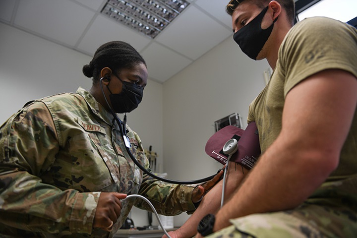 Image of Tech. Sgt. Kimberly Weaver, 606th Air Control Squadron noncommissioned officer in charge of medical readiness, measures an Airman’s blood pressure at Aviano Air Base, Italy, May 10, 2021.