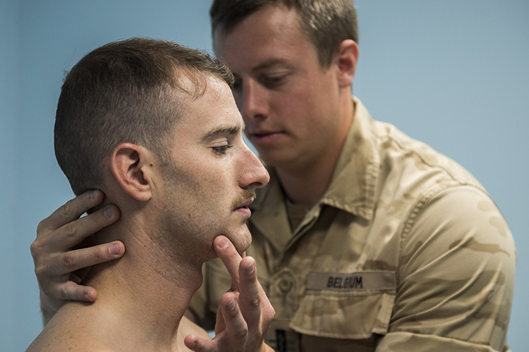 Belgian Medical Component 1st Lt. Olivier, a physical therapist, adjusts the neck of a pilot from the 332nd Air Expeditionary Wing, June 22, 2017, in Southwest Asia. Aircrew from the 332nd AEW received treatment for pains associated with flying high performance aircraft through a partnership program with the Belgian Medical Component. (U.S. Air Force photo/Senior Airman Damon Kasberg)