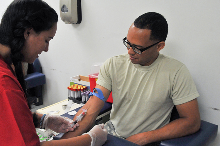 Spc. Jayson Sanchez of the Army Reserve’s 77th Sustainment Brigade receives a blood draw from phlebotomist Nikole Horrell
