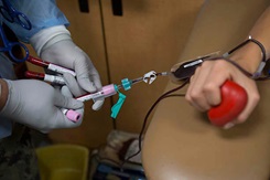 U.S. Marine Corps Lance Cpl. Angel Alvarado, a combat graphics specialist, donates blood for the Armed Services Blood Program (ASBP).