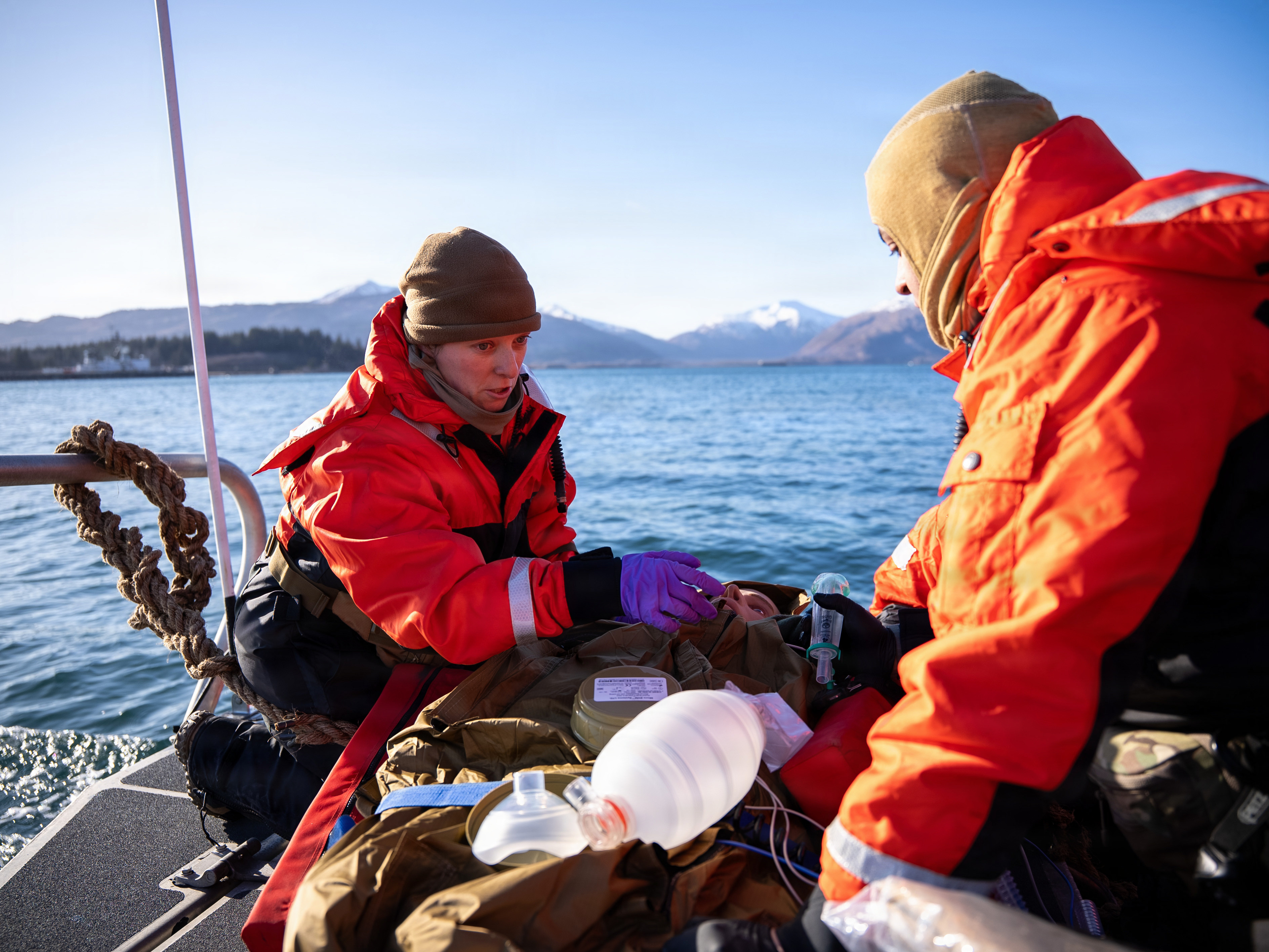 U.S. Navy Lt. Hannah Cunningham, left, assigned to En-route Care System (ERCS) Team 52, and U.S. Navy Hospital Corpsman 1st Class Daniel Rodriguez, right, assigned to ERCS Team 52, treat a patient aboard a small boat