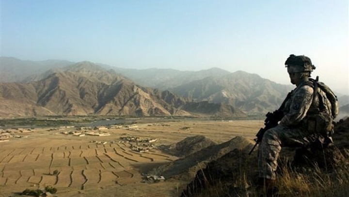 Image of A soldier looks out over a valley in the Kunar Province of Afghanistan while on patrol. .