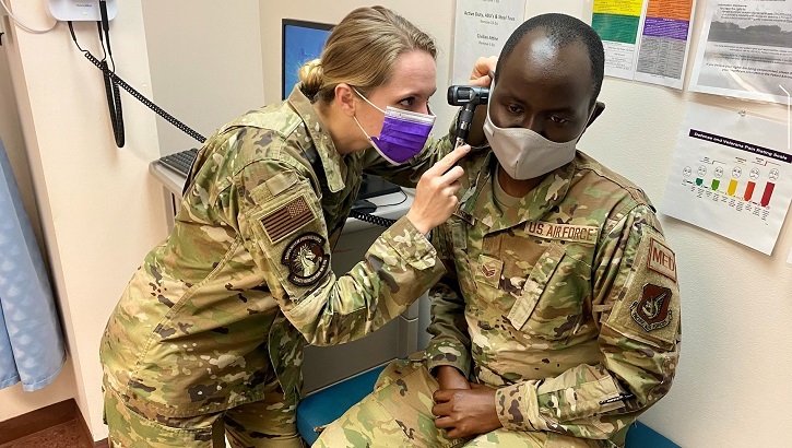 Image of Military health personnel checking the ears of a patient. Click to open a larger version of the image.