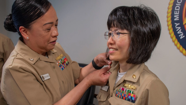 Hoan Nghiem is promoted to the rank of U.S. Navy captain as Capt. Maria Edusada pins the insignia on the Dental Corps officer.