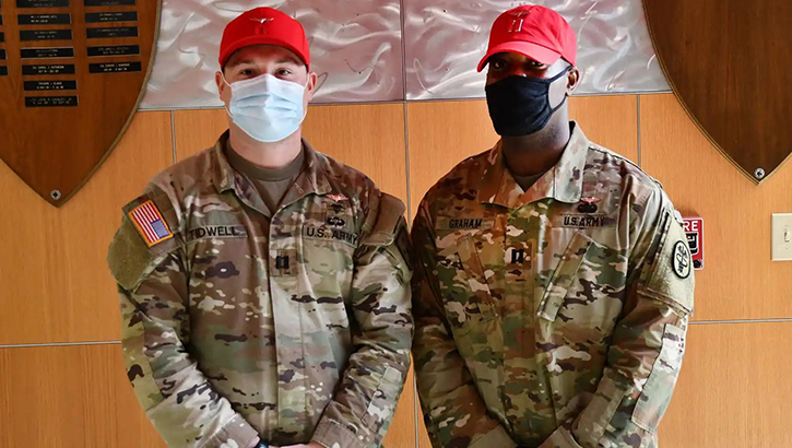 Image of Two military personnel in masks pose for picture. Click to open a larger version of the image.