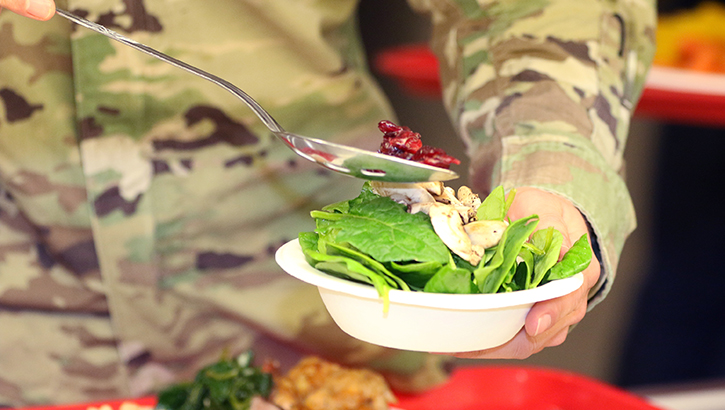 Soldier holding a bowl of lettuce and vegetables