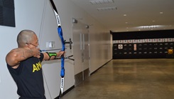 Picture of military personnel wearing a face mask and shooting a bow and arrow