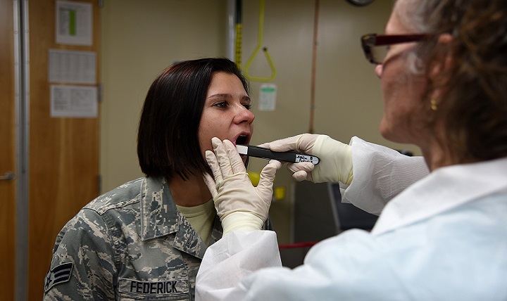 Air Force Senior Airman Ashlin Federick, Armed Forces Medical Examiner System photojournalist, has her cheek swabbed with a Bode buccal swab by Jennie McMahon, AFMES Department of Defense DNA Registry supervisory DNA analyst, at AFMES on Dover Air Force Base, Delaware. Buccal swabs are used to retrieve DNA samples from family references to identify human remains. (U.S. Air Force photo by Senior Airman Ashlin Federick)